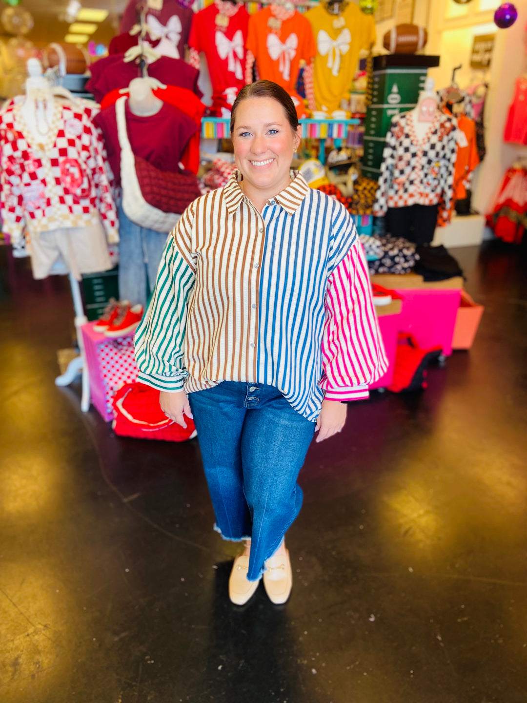 A collared, button-down shirt with ¾ sleeves, featuring a vibrant vertical colorblock stripe pattern in green, beige, blue, and red.