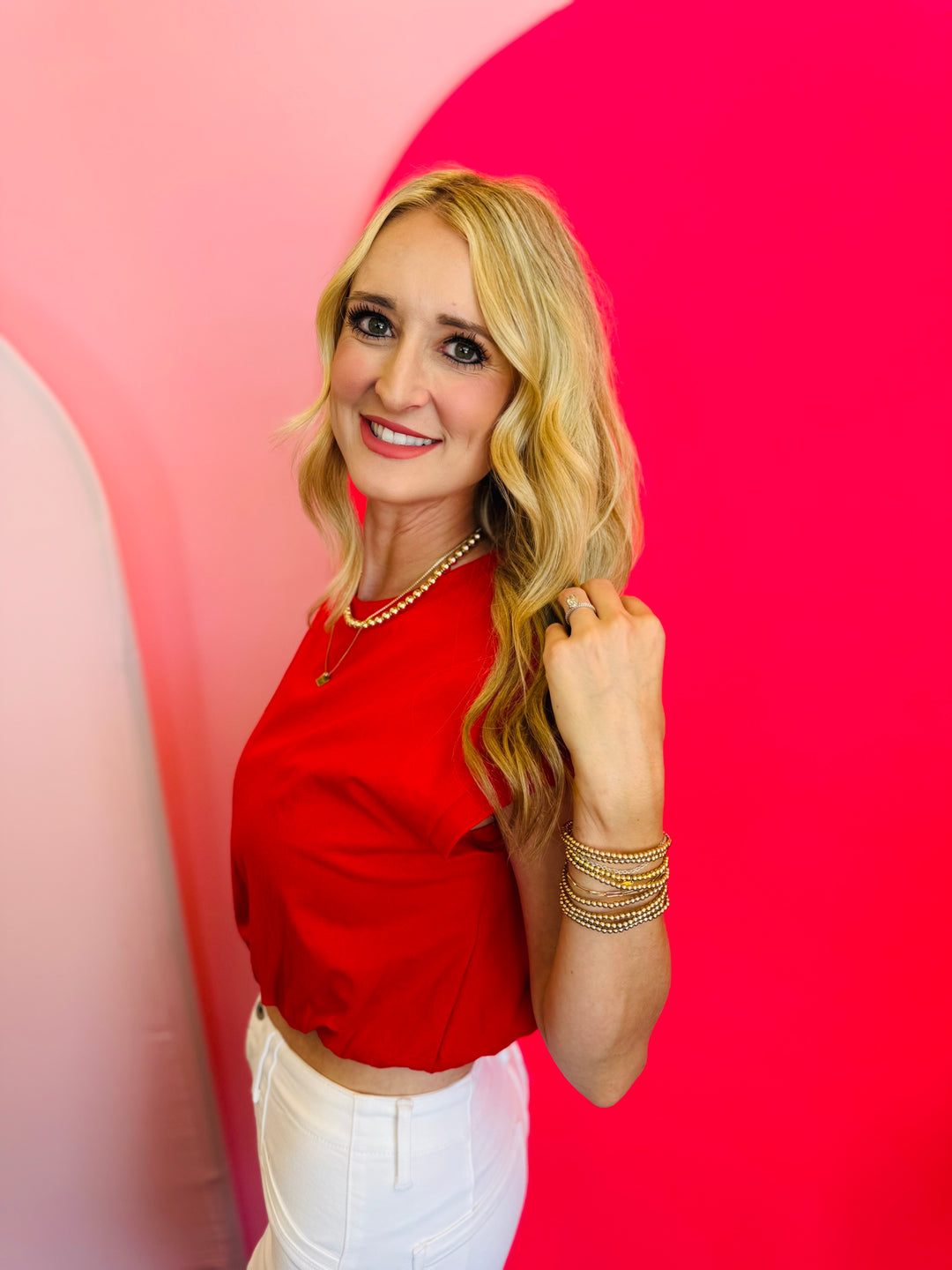 Side profile of the Emma Red Bubble Hem Top, showing the relaxed fit and subtle volume of the bubble hem.