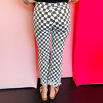Back view of black and white cropped checkered jeans with knee distressing.