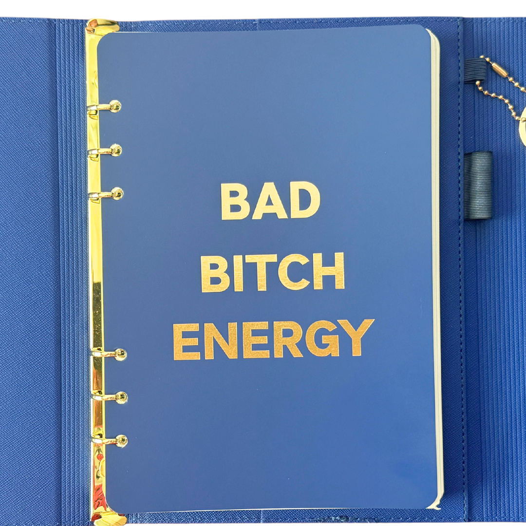 Front page of blue clutch journal folio and calendar with 'BAD BITCH ENERGY' text and colored pen.