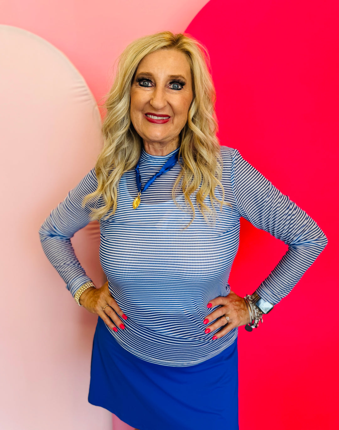 a long sleeve, crewneck mesh top with bold, horizontal stripes in vibrant blue and crisp white.