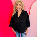 Black scalloped V-neck top with collar and 3/4 sleeves, made from soft, lightweight stretch fabric.
