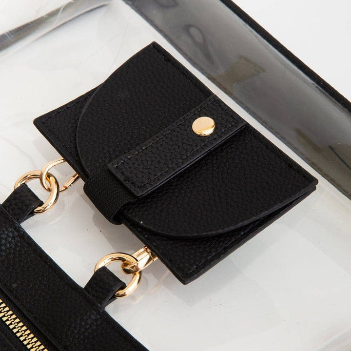 Clear crossbody bag with black trim and gold hardware, featuring a detachable sunglasses holder—fun and functional for any event.