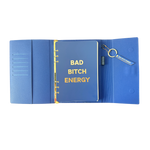 Inside view of blue clutch journal folio and calendar with 'BAD BITCH ENERGY' text and colored pen.
