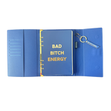 Inside view of blue clutch journal folio and calendar with 'BAD BITCH ENERGY' text and colored pen.