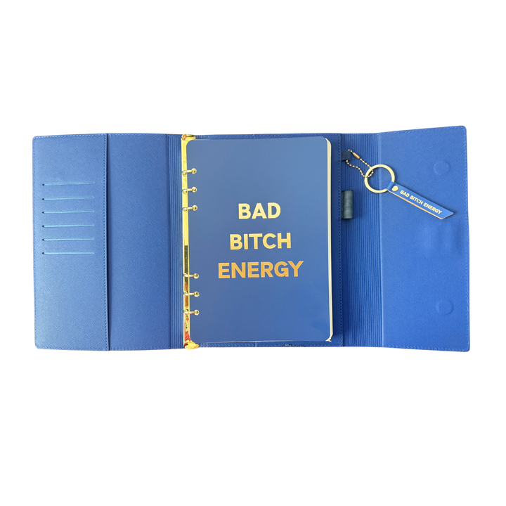 Inside view of blue clutch journal folio and calendar with 'BAD BITCH ENERGY' text and colored pen.