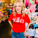 Red tee with pink Christmas cake tree, bow topper, golden snowflakes, and “Merry Christmas” text.
