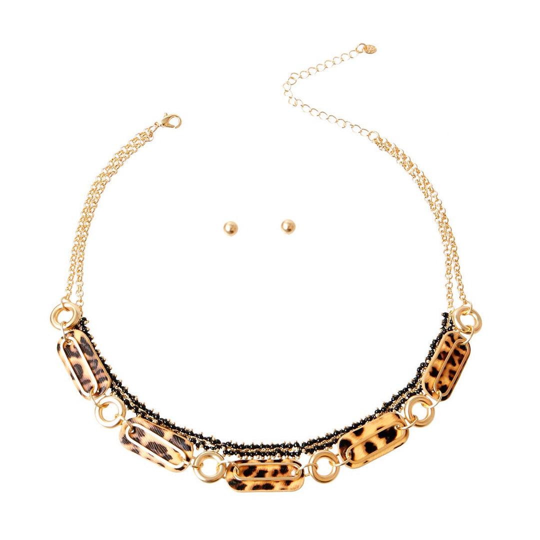 A matte gold layered necklace set featuring leopard print links and black accents.