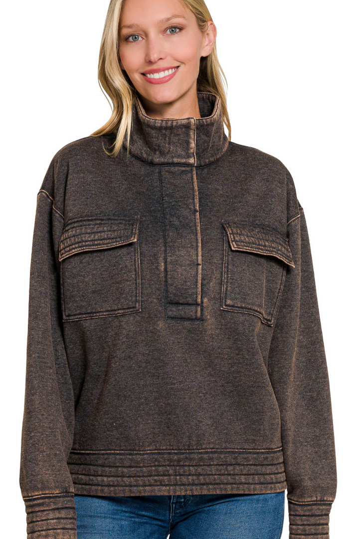 A relaxed-fit, long-sleeve fleece sweatshirt. The sweatshirt has an ash black acid-wash finish, a high collar, and a half-snap button placket at the front.