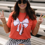 Orange Tultex tee with a white bow and bold black “game day” lettering at the bottom, laid flat for display.