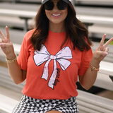 Orange Tultex tee with a white bow and bold black “game day” lettering at the bottom, laid flat for display.