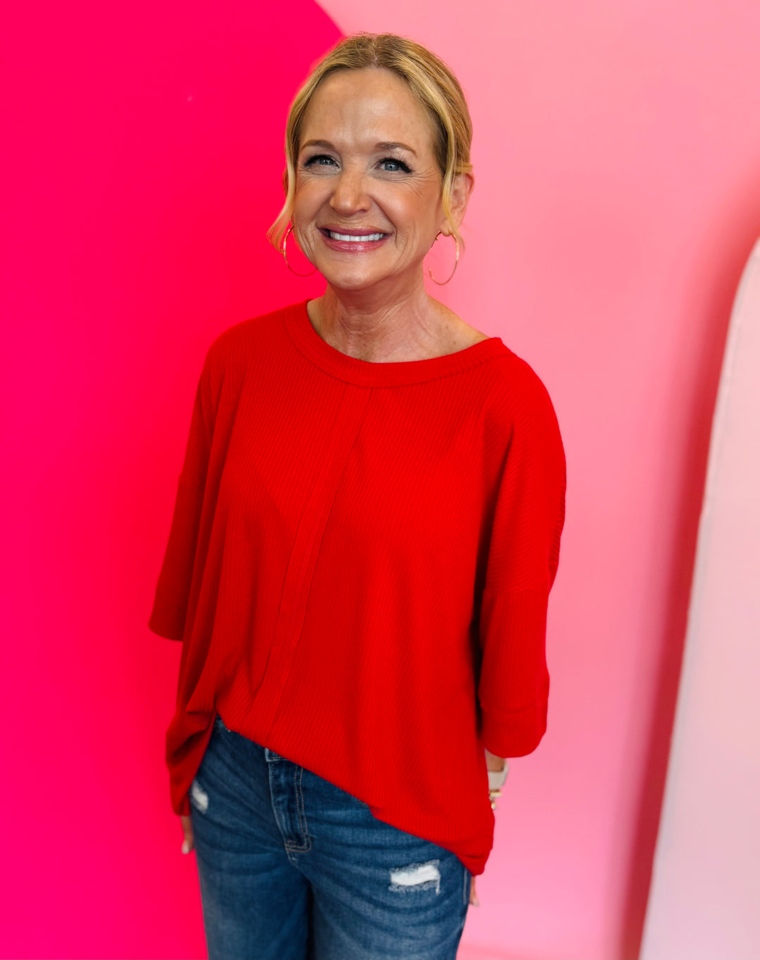 A solid ruby red top with a boat neck and 3/4 sleeves. The top has a noticeable ribbed texture and a relaxed but flattering fit.