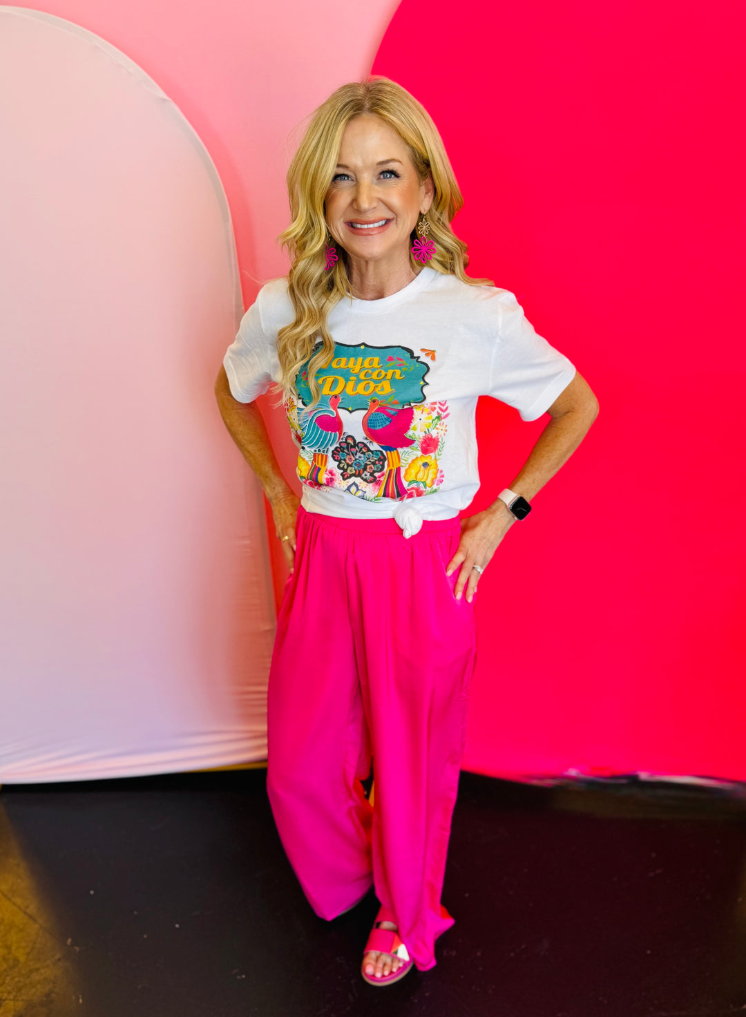 Full outfit view featuring the Vaya Con Dios Tee styled with bright pink pants for a cheerful and vibrant look.