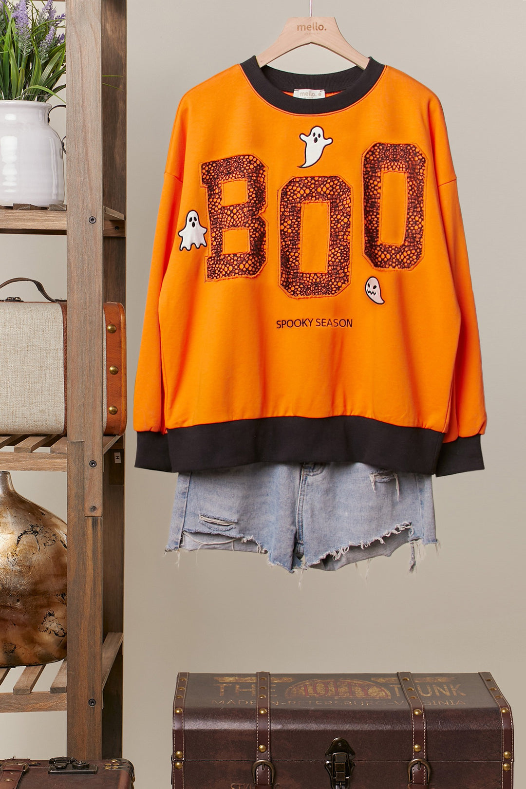 Orange sweatshirt with black neckline, cuff, and hem and  'BOO' and ghost design