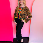 Leopard print rhinestone sweater with rainbow trim and adjustable front ties.