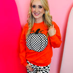Orange crewneck sweatshirt with bold black and white checkered pumpkin graphic, perfect for fall