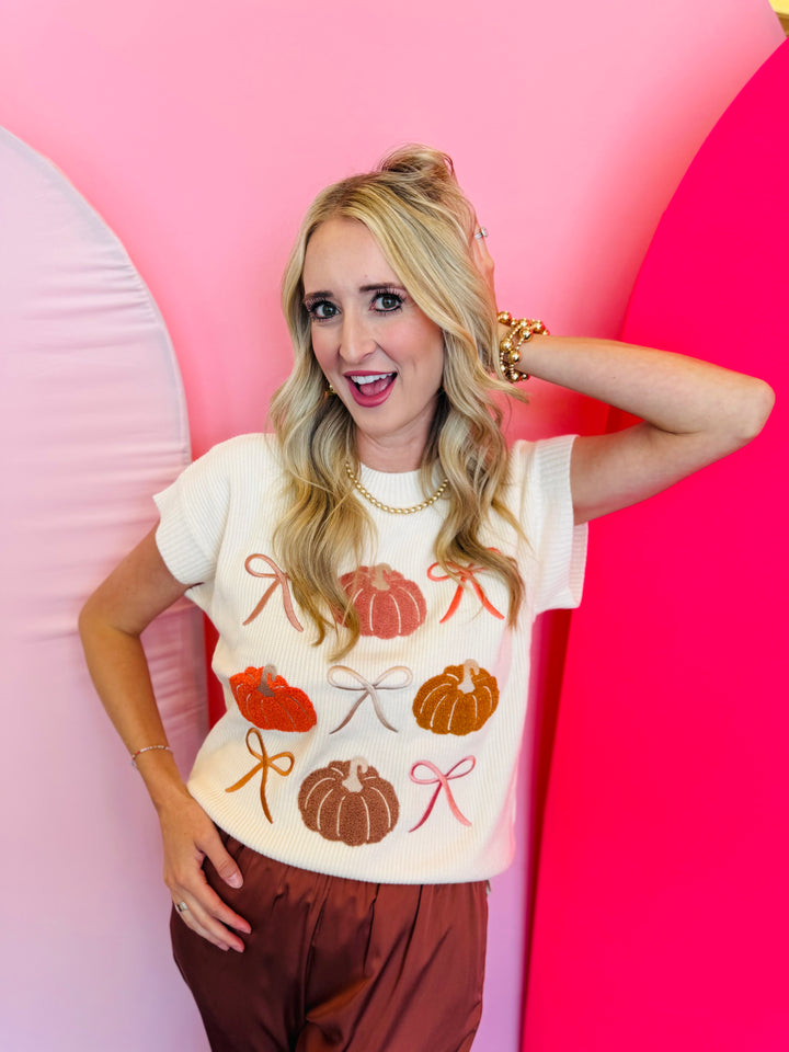 Lightweight knit sweater with rows of colorful pumpkins on a neutral base.