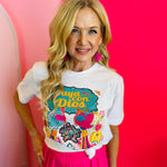 Close-up of the Vaya Con Dios Tee highlighting the colorful floral design and sparkling rhinestone details on the white cotton fabric.