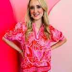 Red & pink tropical print puff sleeve blouse with split V-neck and scalloped trim border.