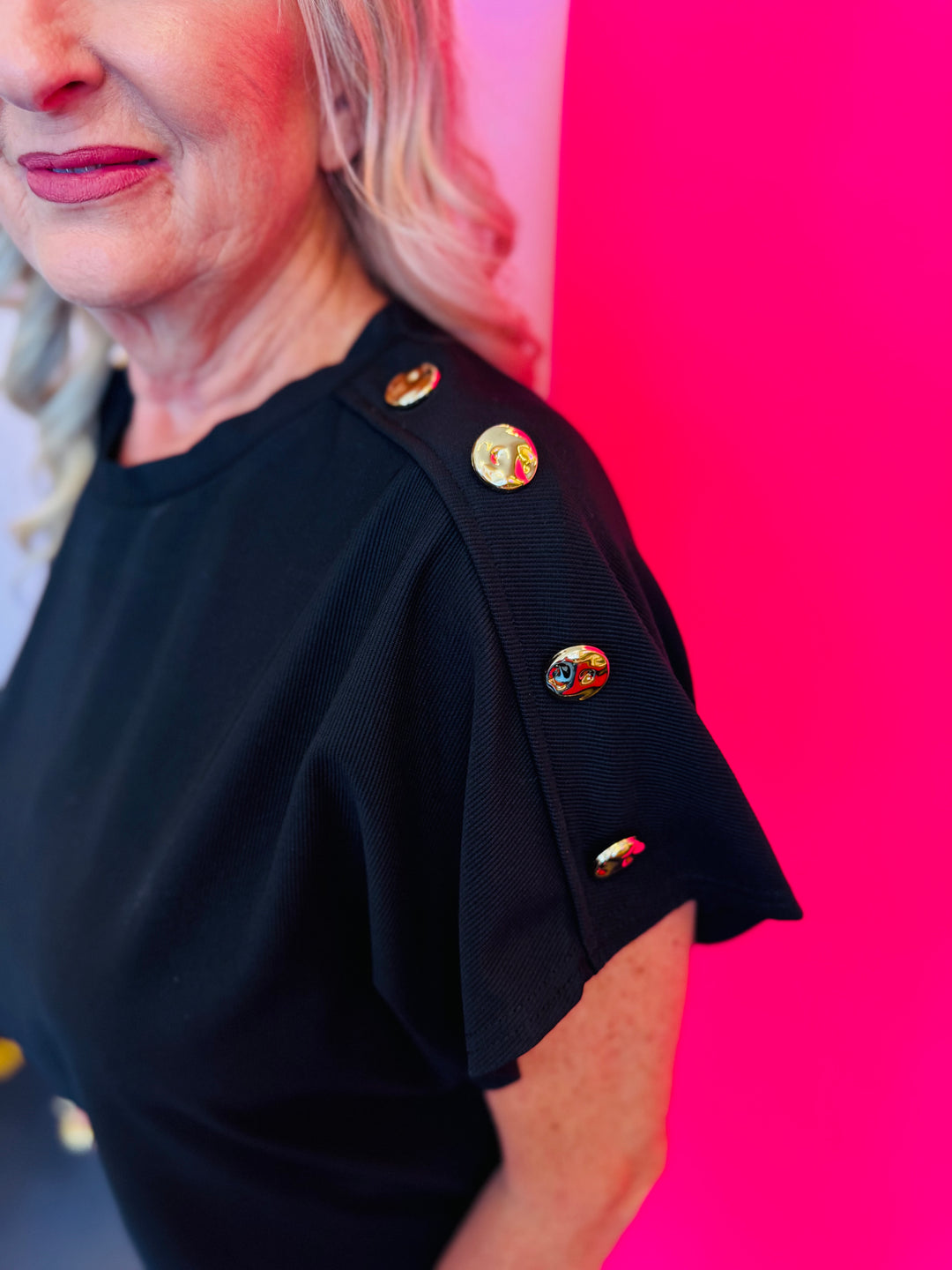 Close-up side view focusing on the row of gold buttons along the sleeve, adding a chic accent to the minimalist design.