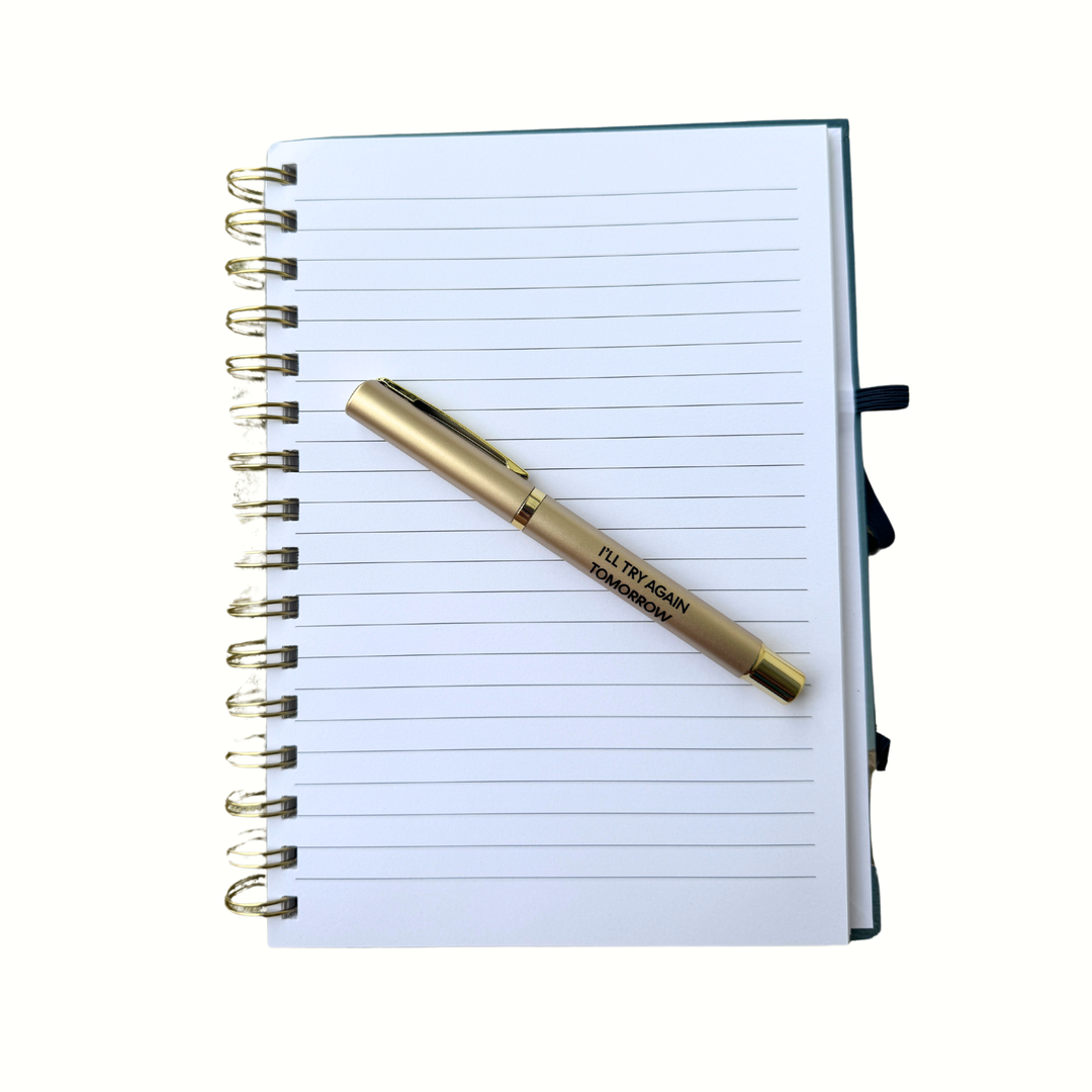 Gold pen with black lettering reading “I’ll Try Again Tomorrow” 