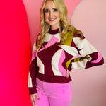 Burgundy mock neck sweater with abstract blush and golden intarsia pattern in soft knit fabric.