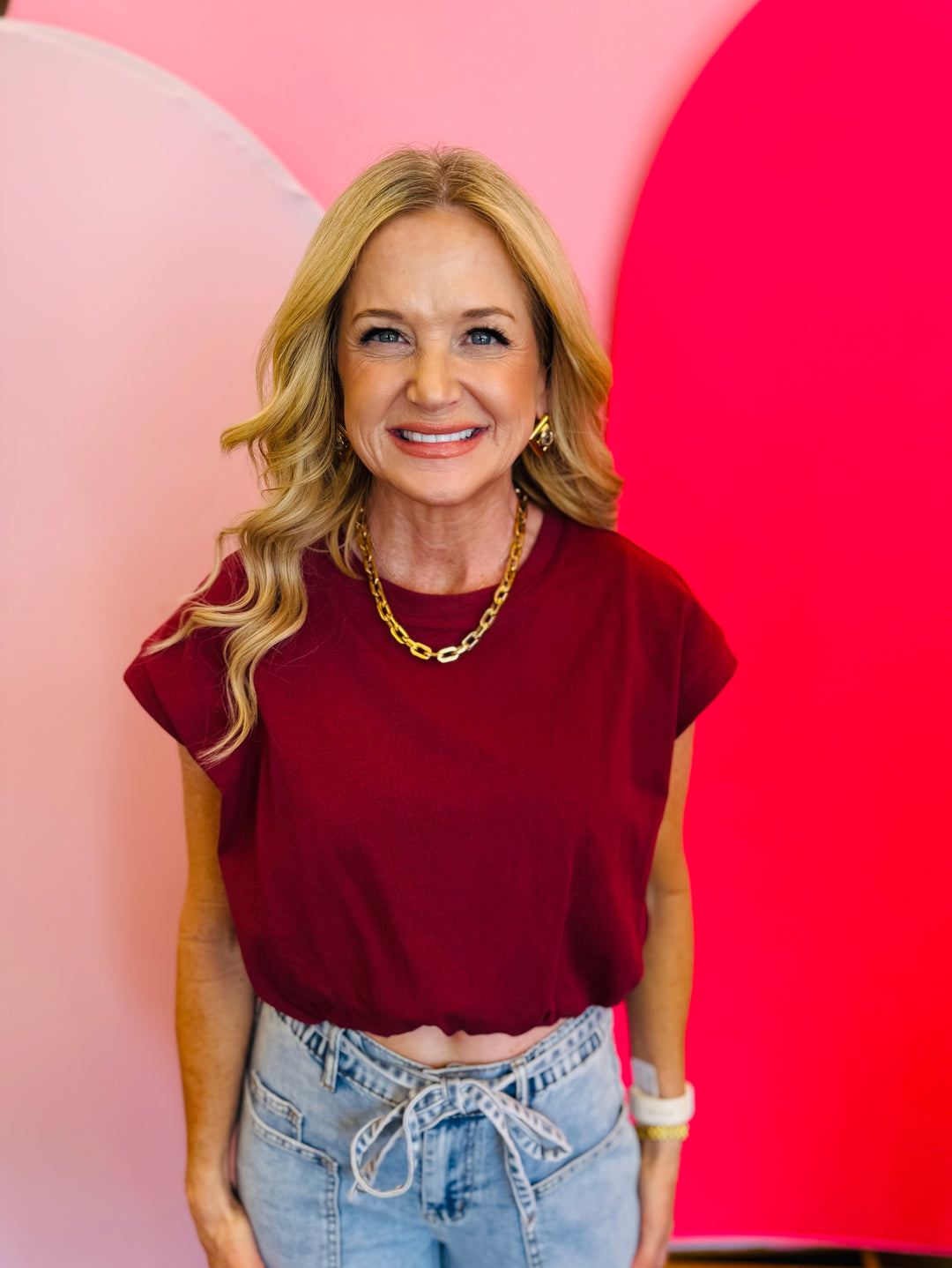 Close-up of the Emma Bubble Hem Top highlighting the rich burgundy color, capped short sleeves, and soft gathered bubble hemline.