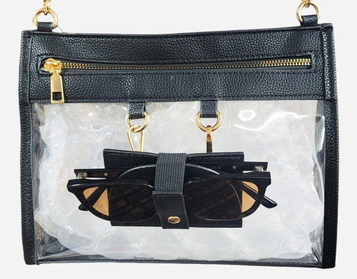 Clear crossbody bag with black trim, gold hardware, and a detachable sunglasses holder—fun, functional, and stadium-approved.