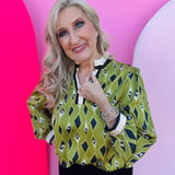 Olive, navy, and cream diamond-print blouse with ruffled neckline, contrast trim, and long elastic-cuff sleeves.