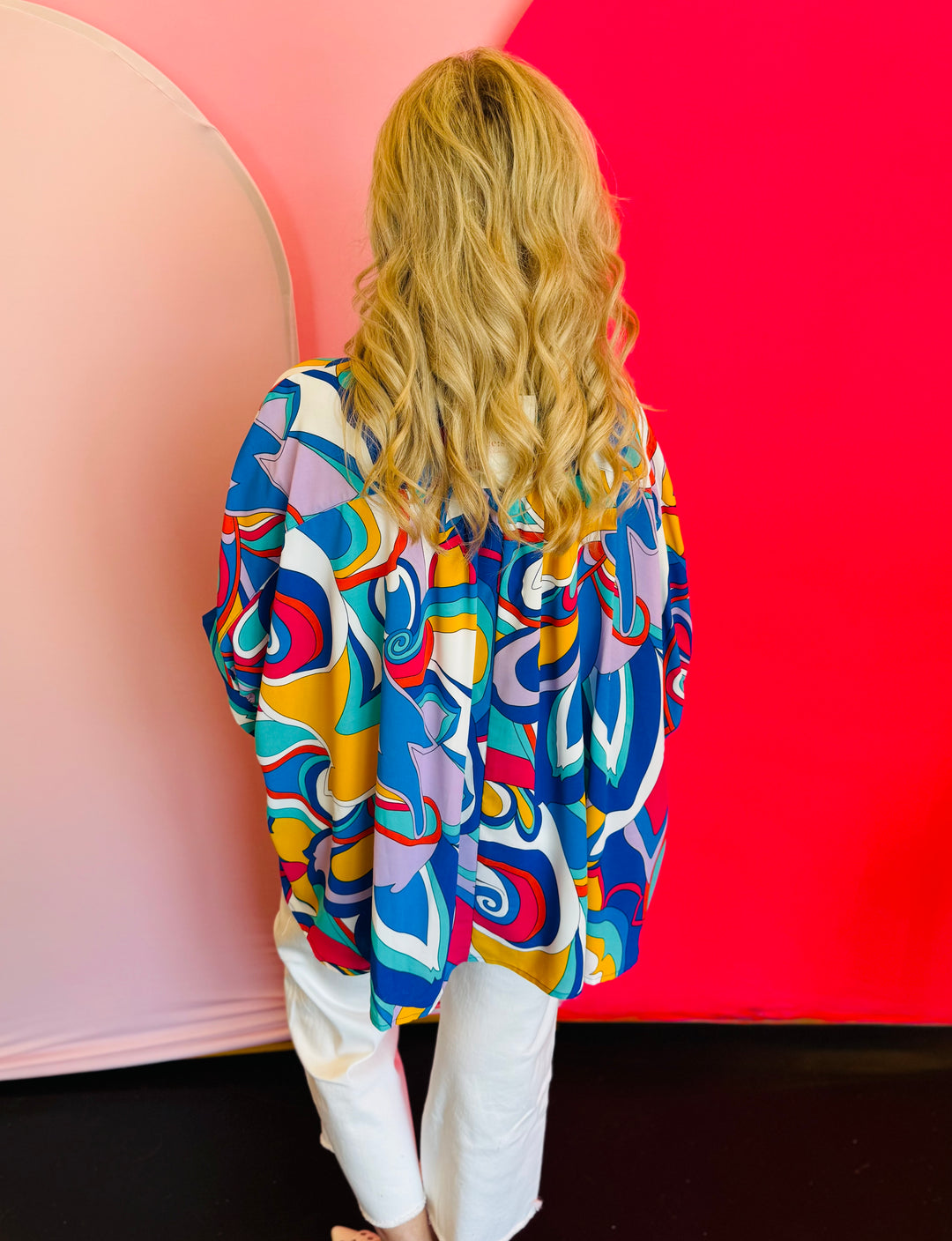 Back view of the blouse displaying the pinched detail at the upper back and the relaxed silhouette of the lightweight fabric.