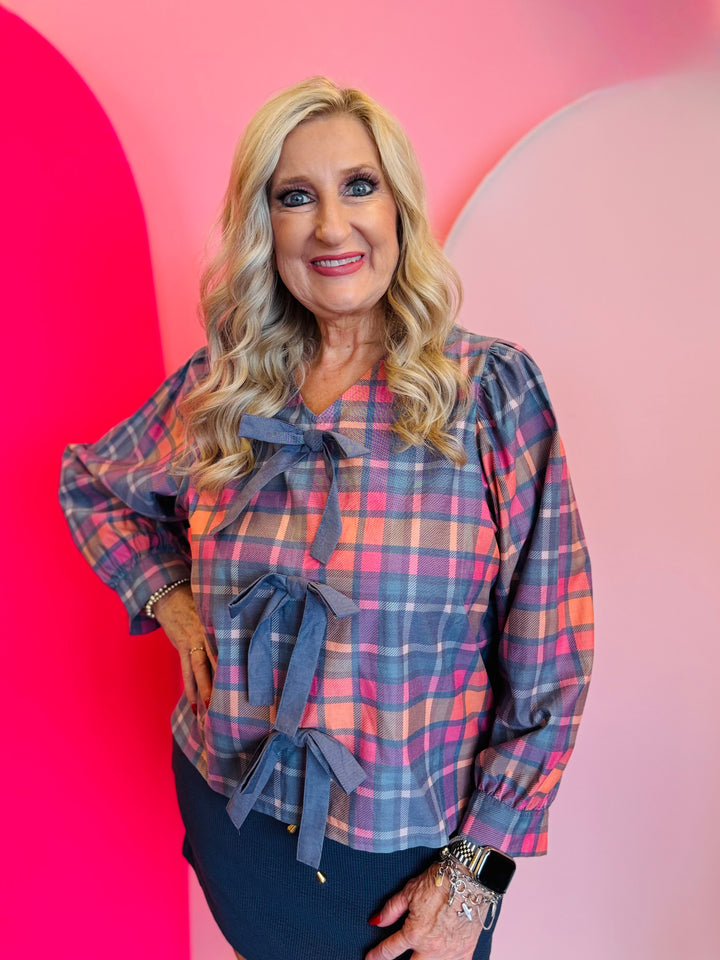 Plaid top in pink and blue with front bows, long sleeves.