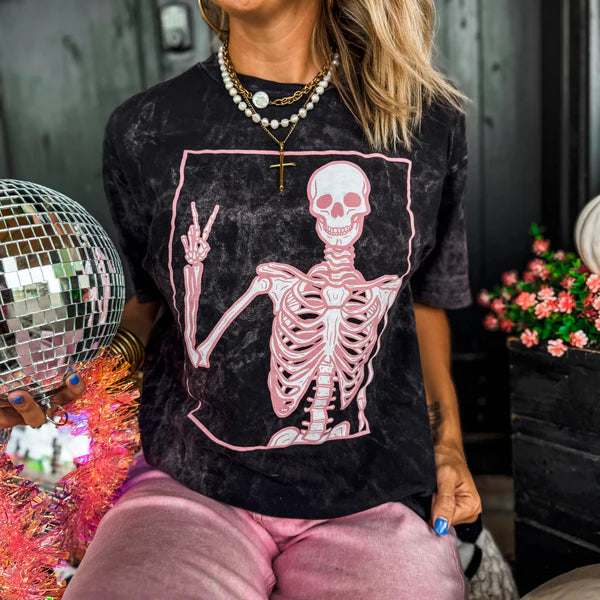 Black mineral wash tee with a pink peace sign skeleton graphic.