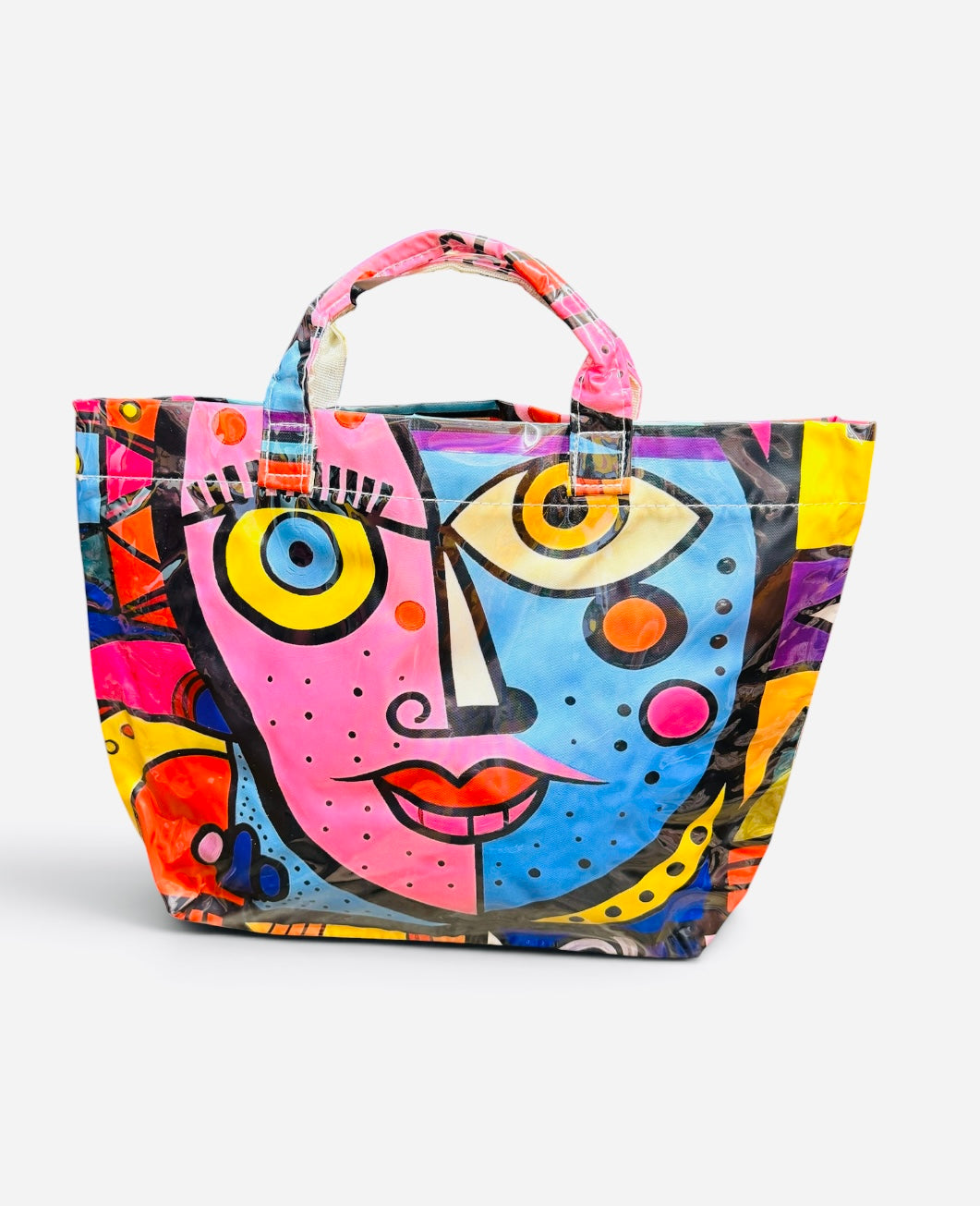 Glossy PVC tote bag with colorful pink, blue, yellow, orange, and purple abstract face design.