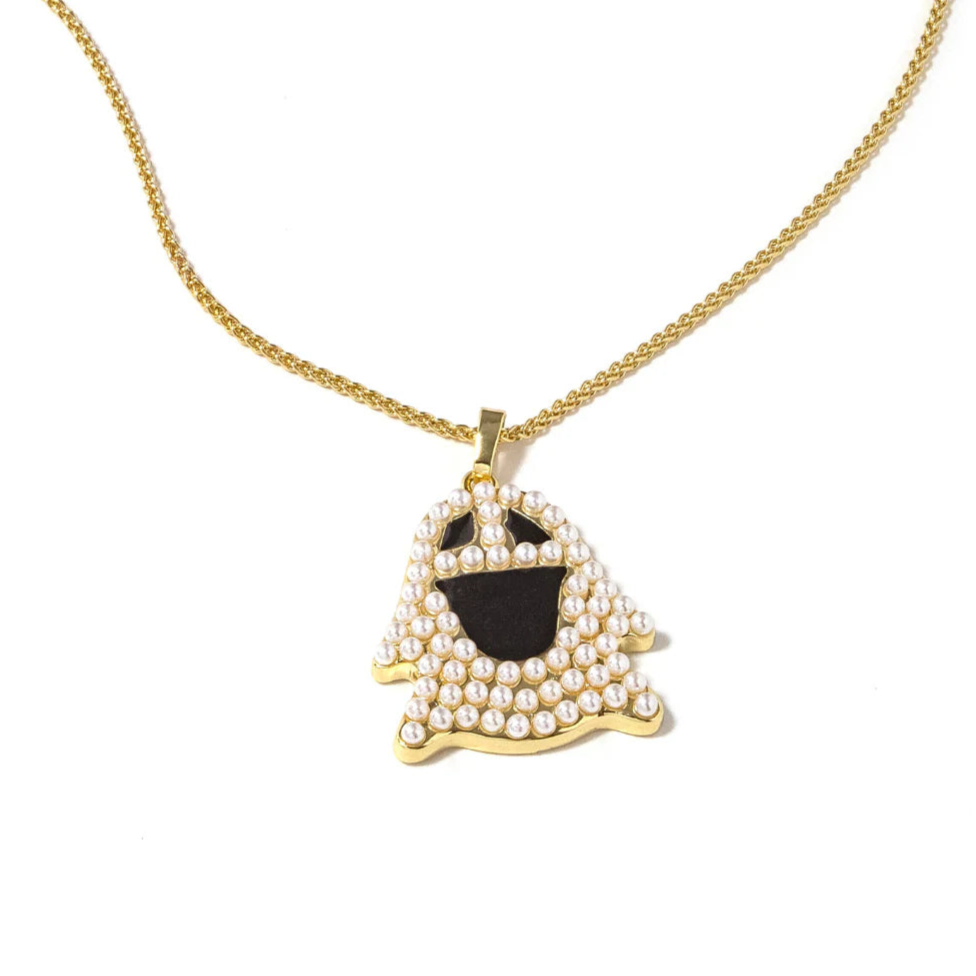 An elegant yet edgy gold necklace featuring a ghost pendant with pearls. 