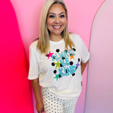 Cream graphic tee with turquoise Always Be Kind lettering, stars, and black polka dot accents