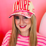 White hat with pink AMORE embroidery and whimsical patchwork bill with heart details.