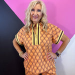 Brown rust and cream geometric quarter zip top with striped trim and side slits.