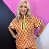 Brown rust and cream geometric quarter zip top with striped trim and side slits.