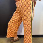 Brown rust and cream mosaic wide-leg pants with mustard striped side accents.