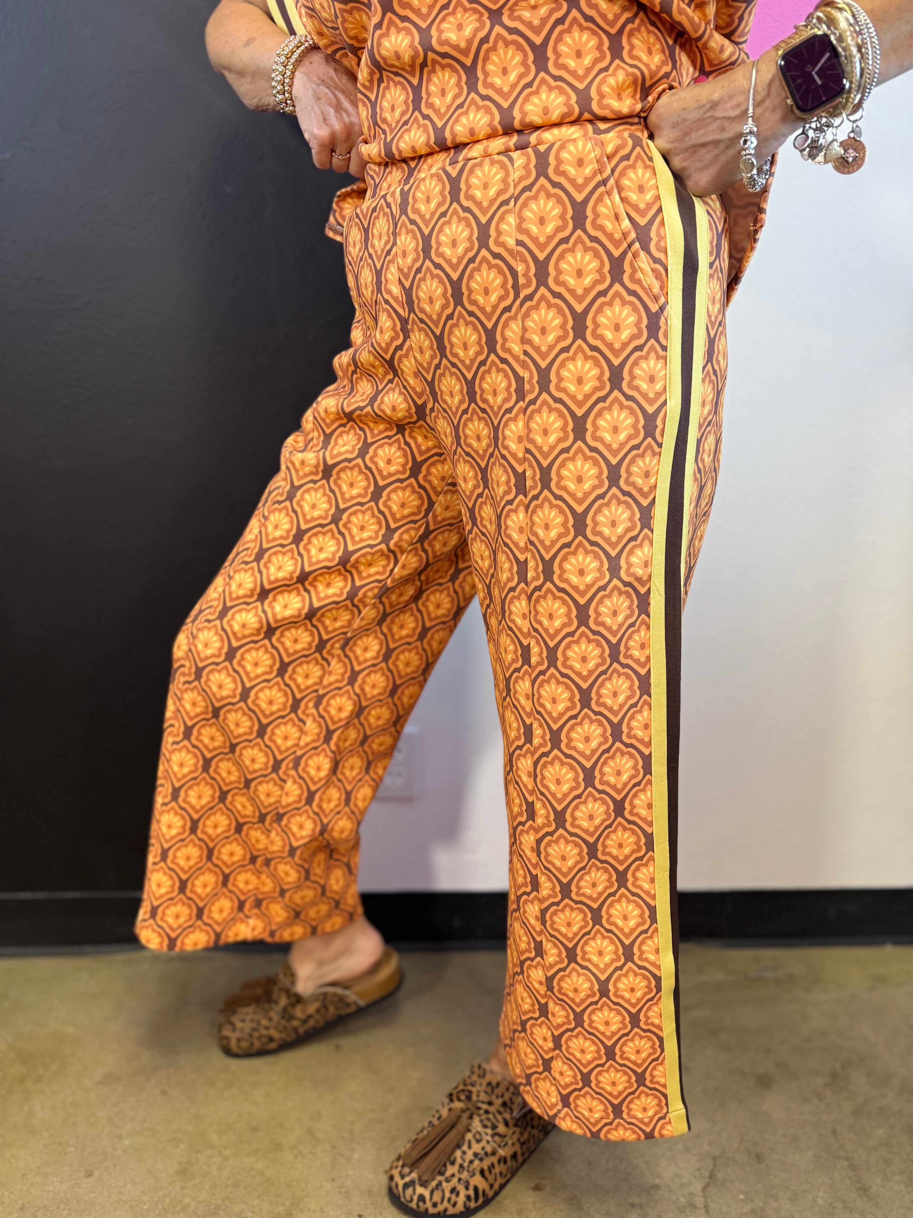 Brown rust and cream mosaic wide-leg pants with mustard striped side accents.