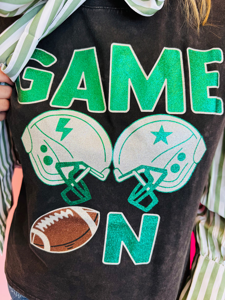 Close up of Sleeveless black tee with green graphics, helmet, and football.