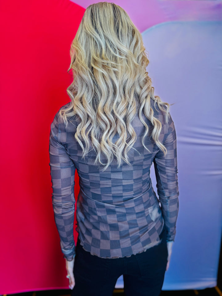 Back view of the Keigan Mesh Top showcasing the playful chocolate checkered print, sheer lightweight mesh fabric, and stylish lettuce-edge hem, offering a bold and breathable statement piece perfect for layering.