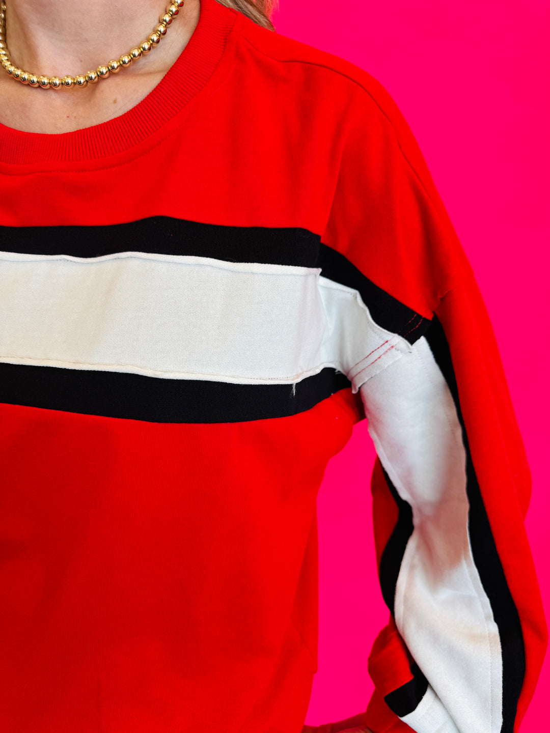 Close up of Colorblock red top with white and black stripe.