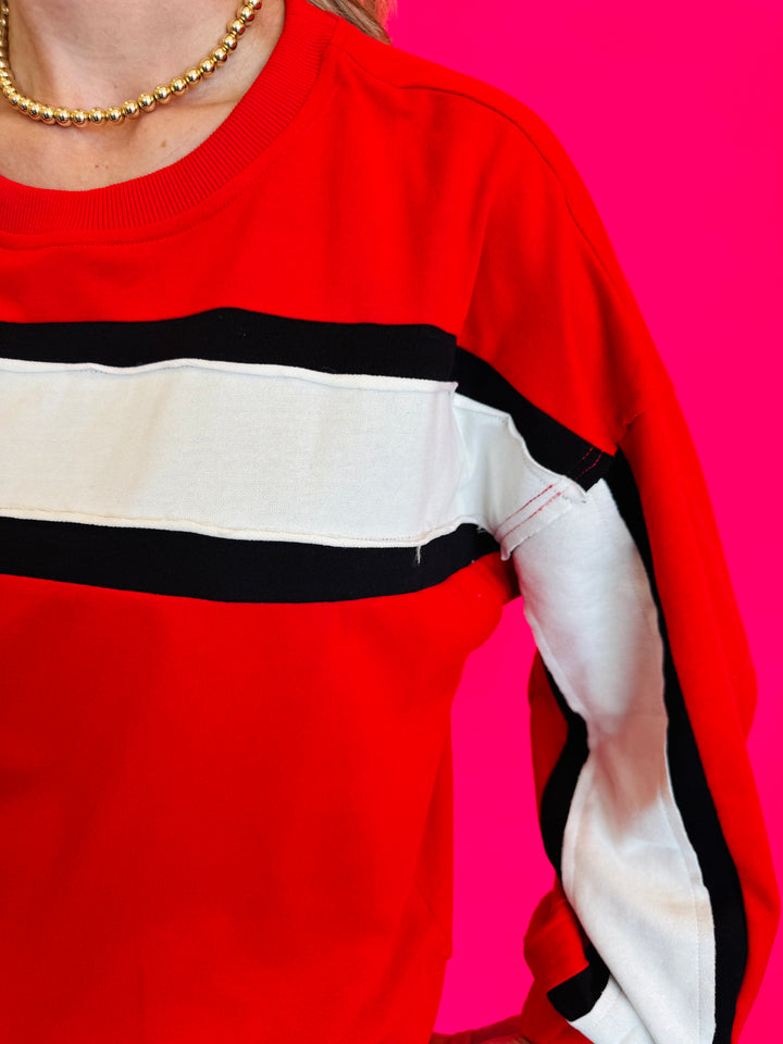 Close up of Colorblock red top with white and black stripe.