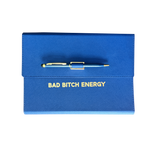 Blue clutch journal folio and calendar with 'BAD BITCH ENERGY' text and colored pen.