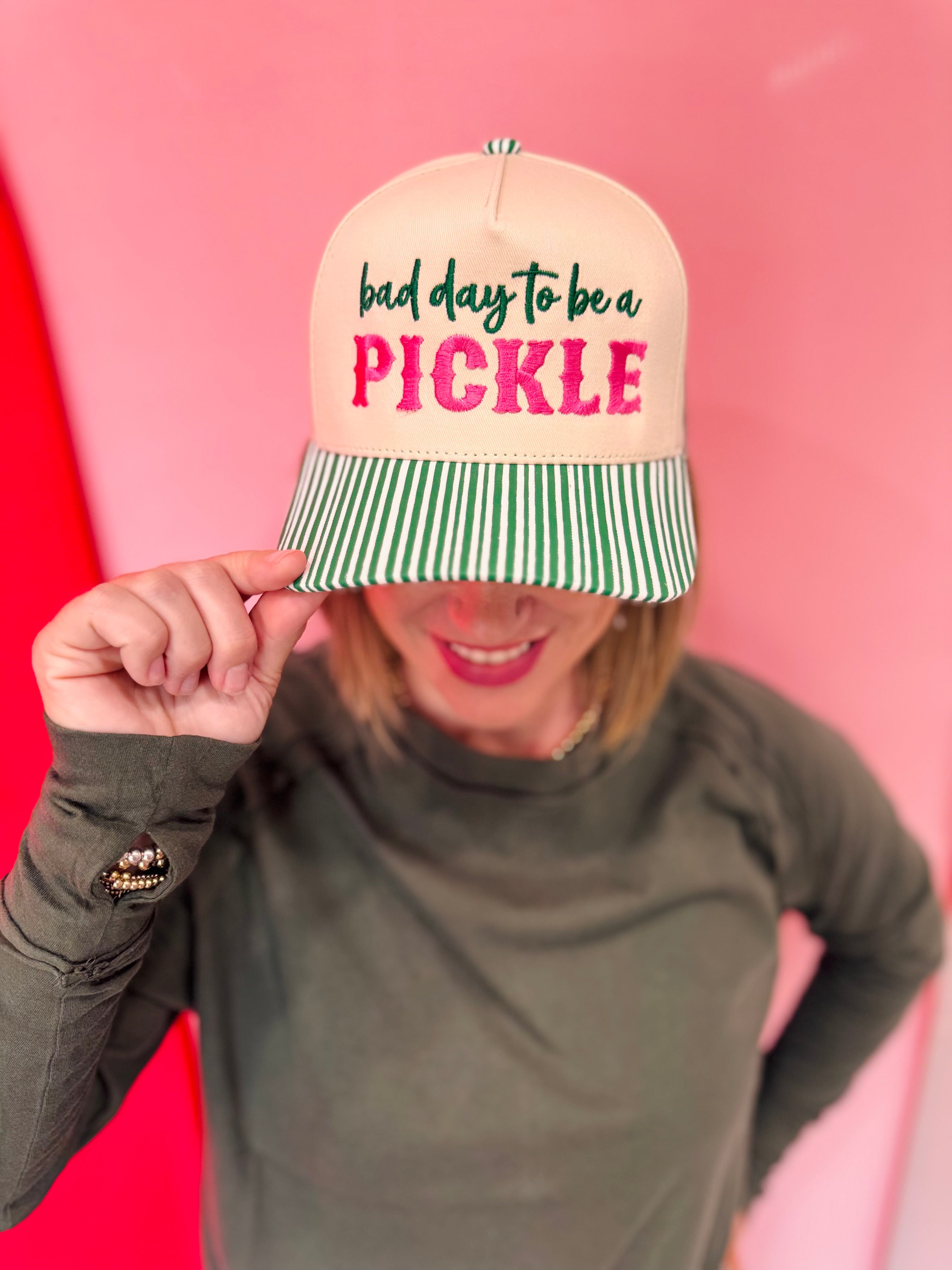 Cream pickleball hat with pink embroidery and green striped bill.