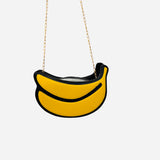 Yellow banana shaped crossbody bag with gold chain strap and zip closure.