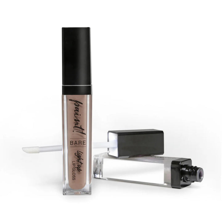 A tube of lip gloss with its lighted LED wand turned on, next to the built-in side mirror.