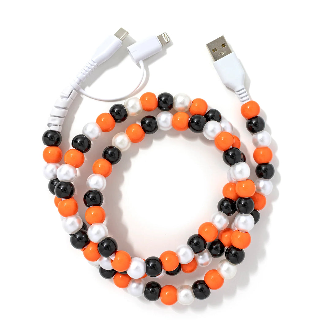 A vibrant orange, black, and pearl beaded phone charger cable.