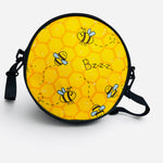 Yellow bee crossbody purse with honeycomb print and zip closure.